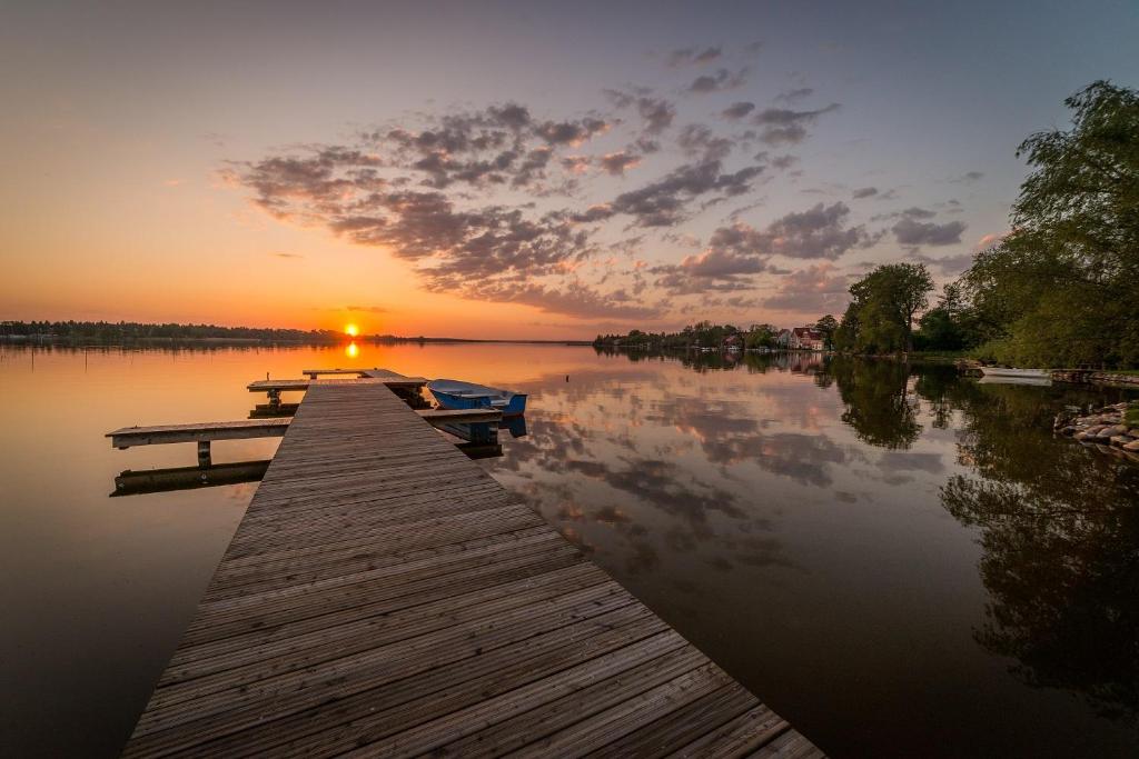 przystań z dwoma łodziami nad jeziorem o zachodzie słońca w obiekcie Pensjonacik Krystyna - Pension Krystyna w mieście Mikołajki