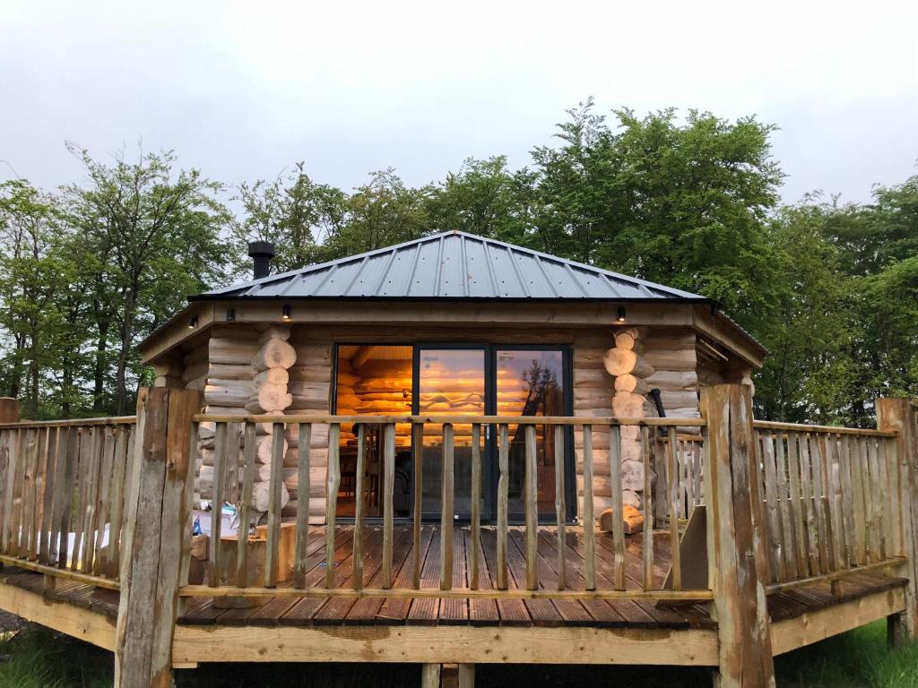uma cabana de madeira com um telhado preto em Coed y Marchog Woodland Retreat em Hereford