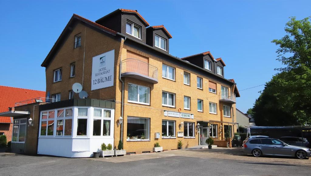 een gebouw waar een auto voor geparkeerd staat bij Hotel 12 Bäume in Werne an der Lippe