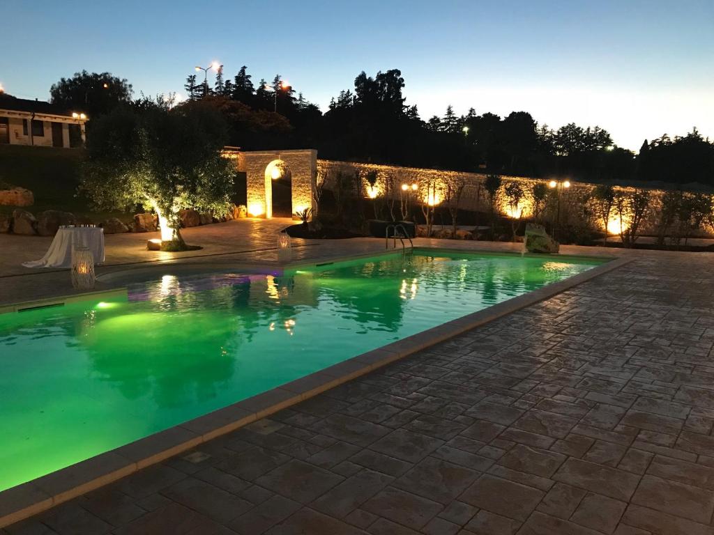 una piscina in un cortile posteriore di notte di Relais Masseria Serritella a Castellana Grotte
