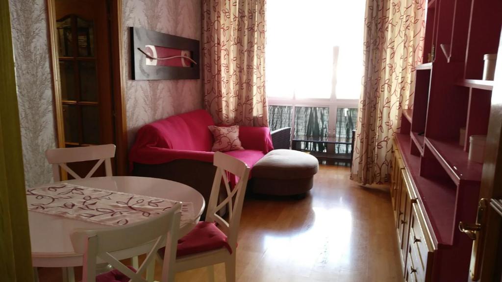 トレモリノスにあるPiso 3 dormitorios centro de Torremolinos 11349のテーブル、椅子、テーブル、窓が備わる客室です。