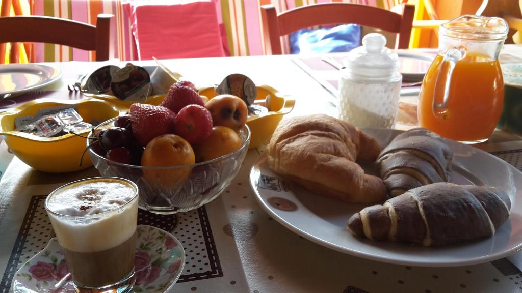 a table with a plate of pastries and a cup of coffee at Villa Salvatore in San Leone