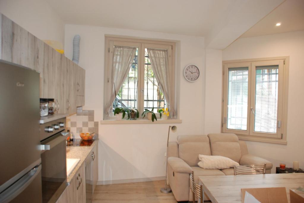 cocina y sala de estar con sofá y mesa en Casa Anita, en Limone sul Garda