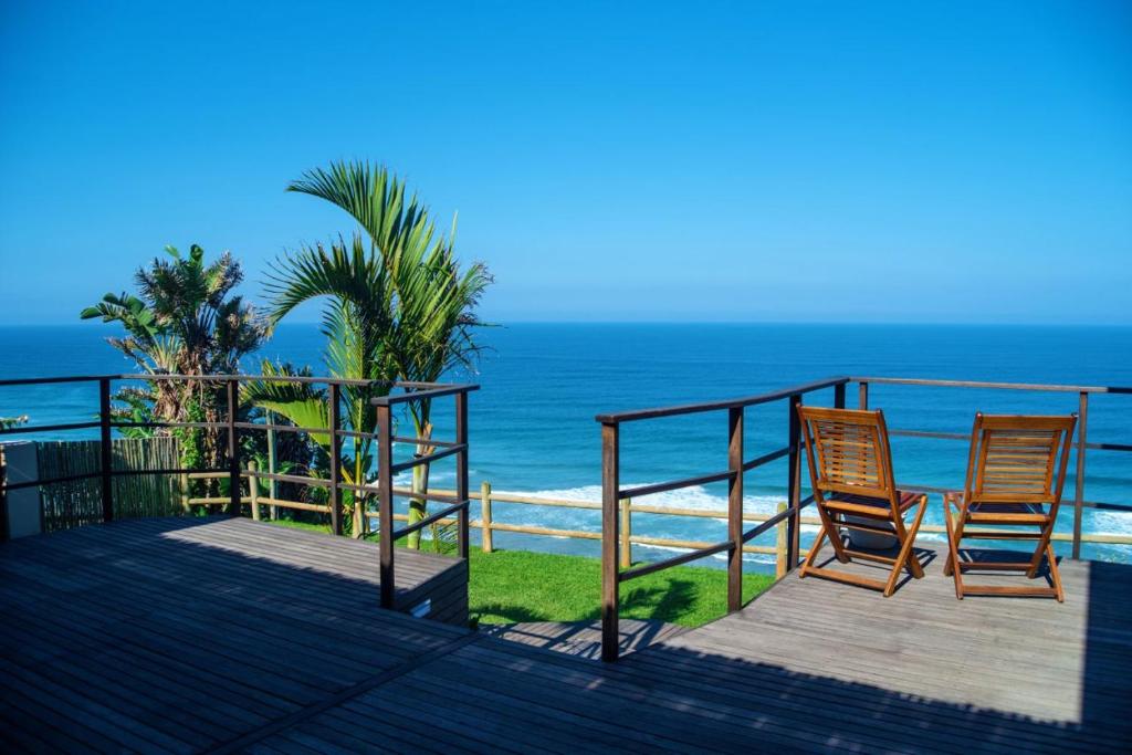 two chairs sitting on a deck overlooking the ocean at The Tides Inn in Durban