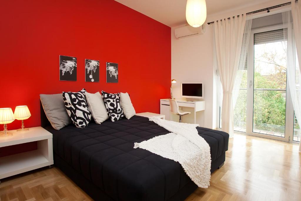 a bedroom with red walls and a bed with pillows at Boutique Apartments 360º in Belgrade