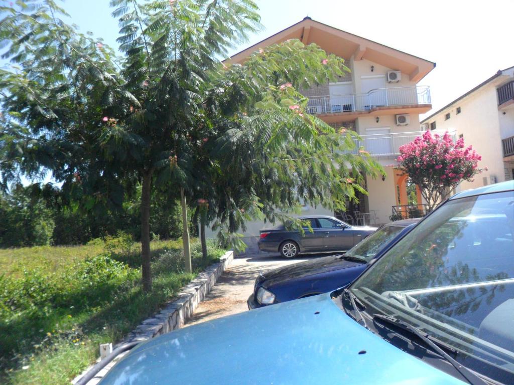 a blue car parked in a parking lot with trees at Sobe u kucanstvu MBM in Međugorje