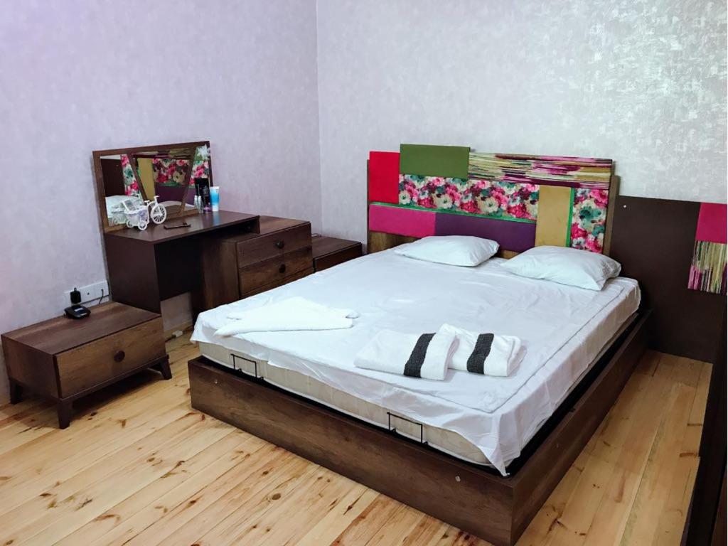 a bedroom with a large bed and a desk at Baku Central Apartment in Baku