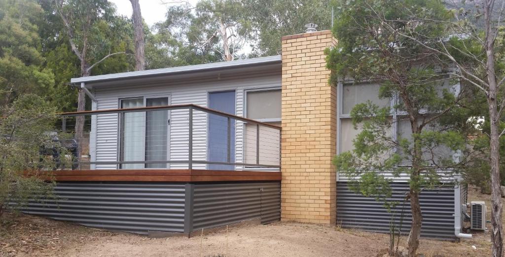 a house with a balcony on the side of it at Wattletree Cottage in Halls Gap