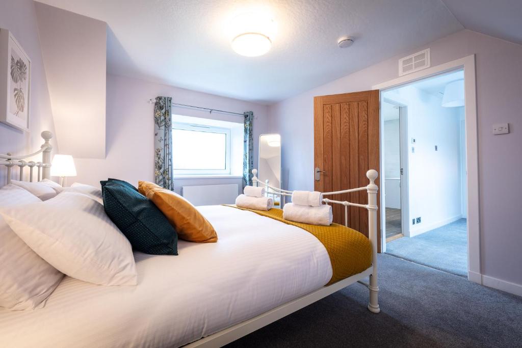 sypialnia z dużym białym łóżkiem z poduszkami w obiekcie Lochside w mieście Staffin