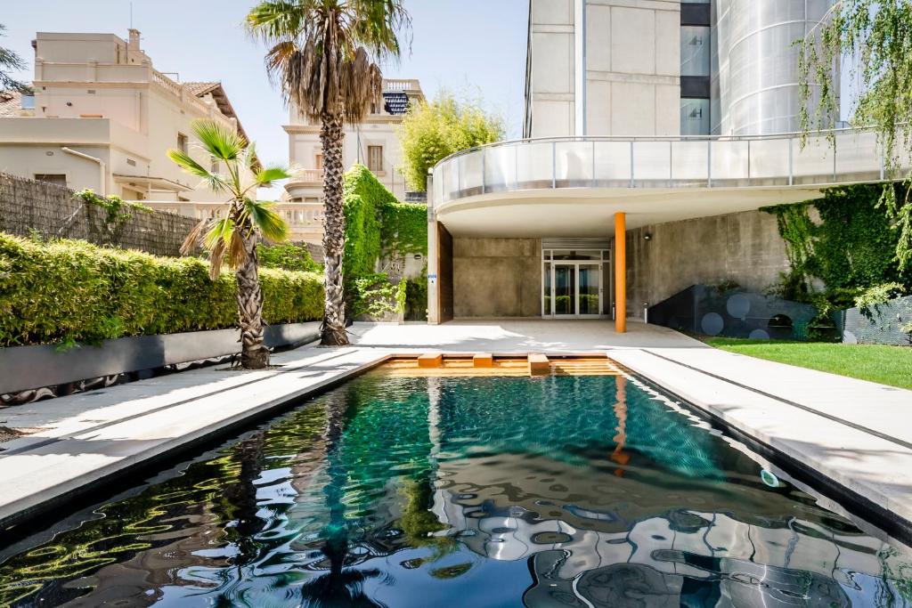 a swimming pool in front of a building with a house at Ikonik Anglí in Barcelona