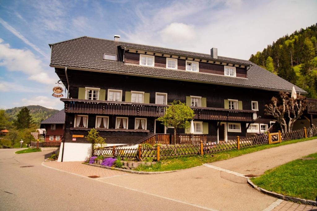 une grande maison brune avec un toit noir dans l'établissement Gästehaus Erika, à Menzenschwand