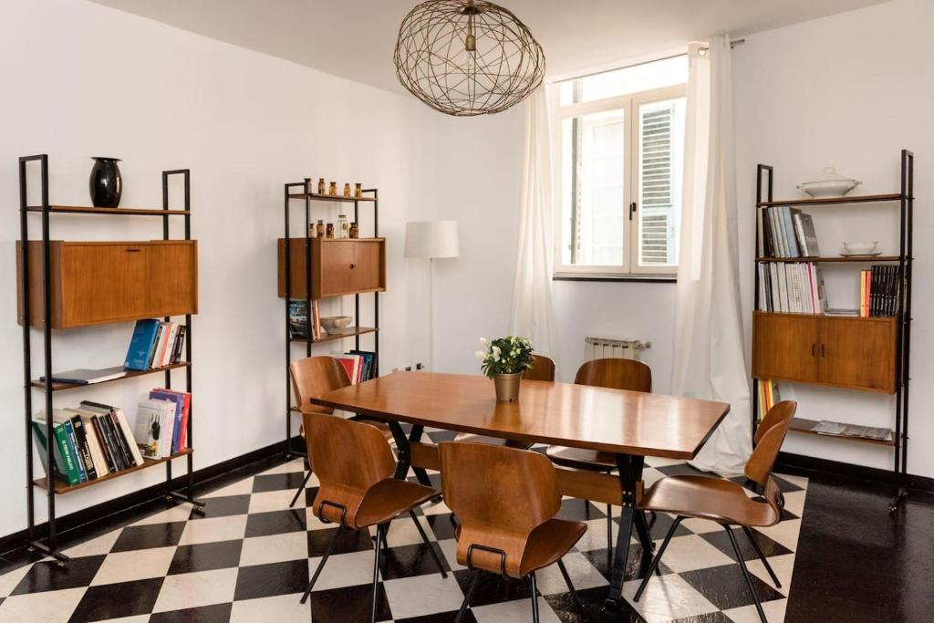 - une salle à manger avec une table, des chaises et un sol en damier dans l'établissement San Matteo 23, à Gênes