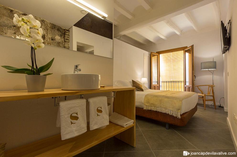 Hotel Secrets Priorat في فالسيت: حمام مع مغسلة وسرير في الغرفة