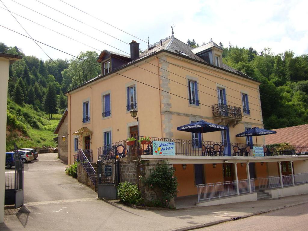 un edificio con sombrillas en el balcón. en Chambres d'hôtes Résidence du Parc, en Plombières-les-Bains