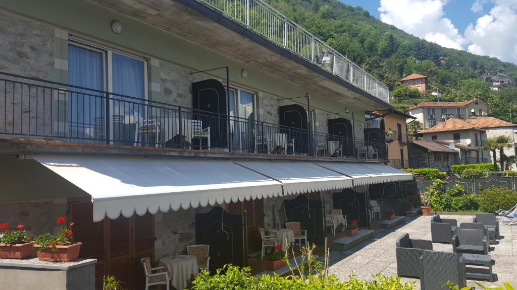 ein Gebäude mit einem Balkon mit Stühlen und Tischen in der Unterkunft Albergo Del Lago in Cannobio