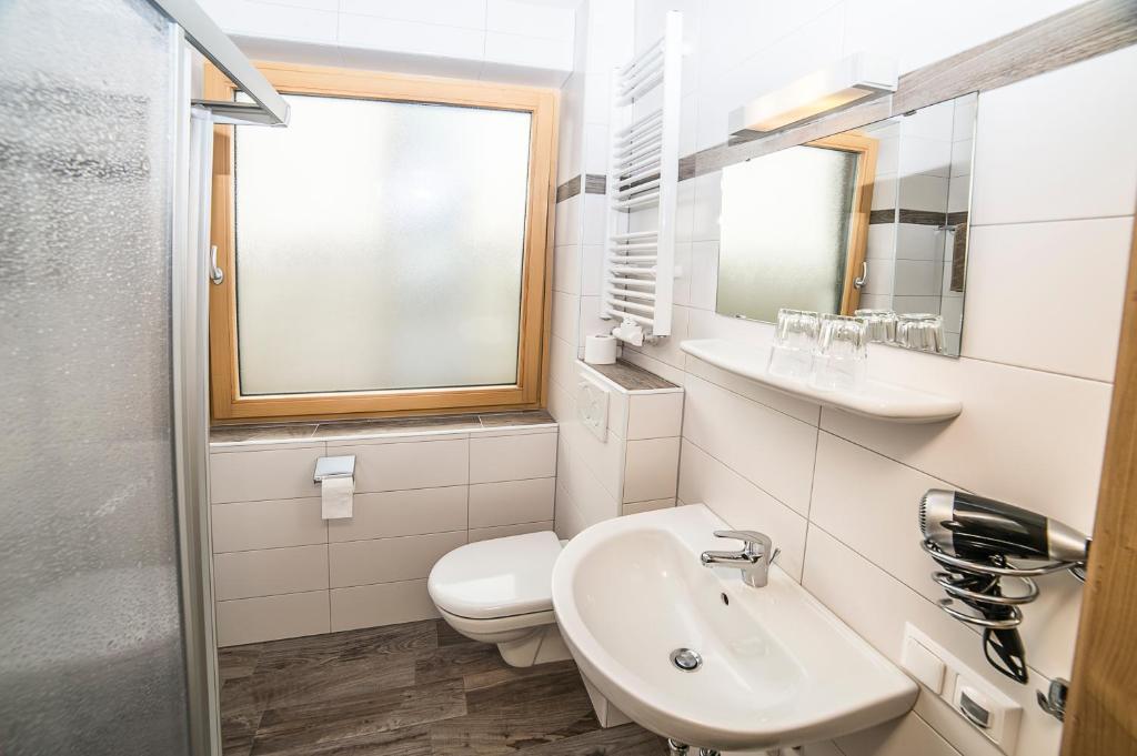 a bathroom with a sink and a toilet and a window at Familie Lampersberger in Sachsenburg