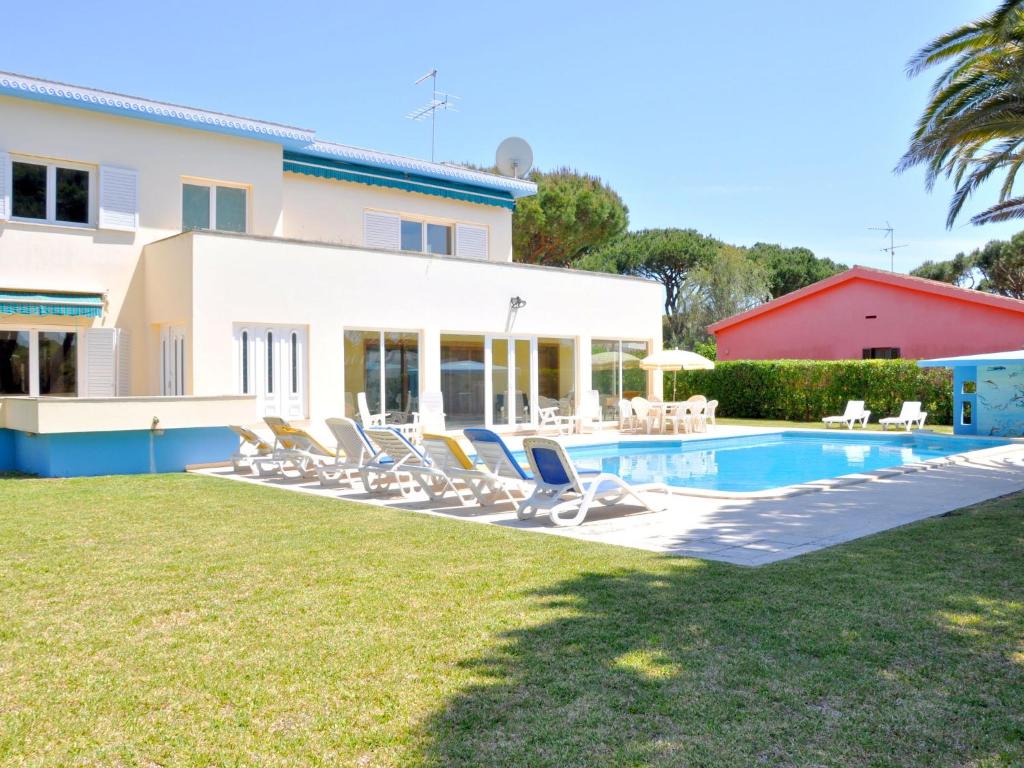 a villa with a swimming pool and lounge chairs at Spacious Villa in Vilamoura with Barbecue in Vilamoura