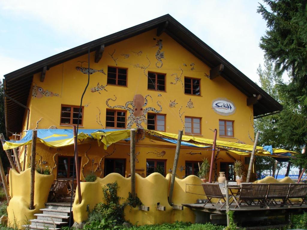 a yellow house with a painting on the side of it at Schiff Bihlerdorf - Hostel in Bihlerdorf