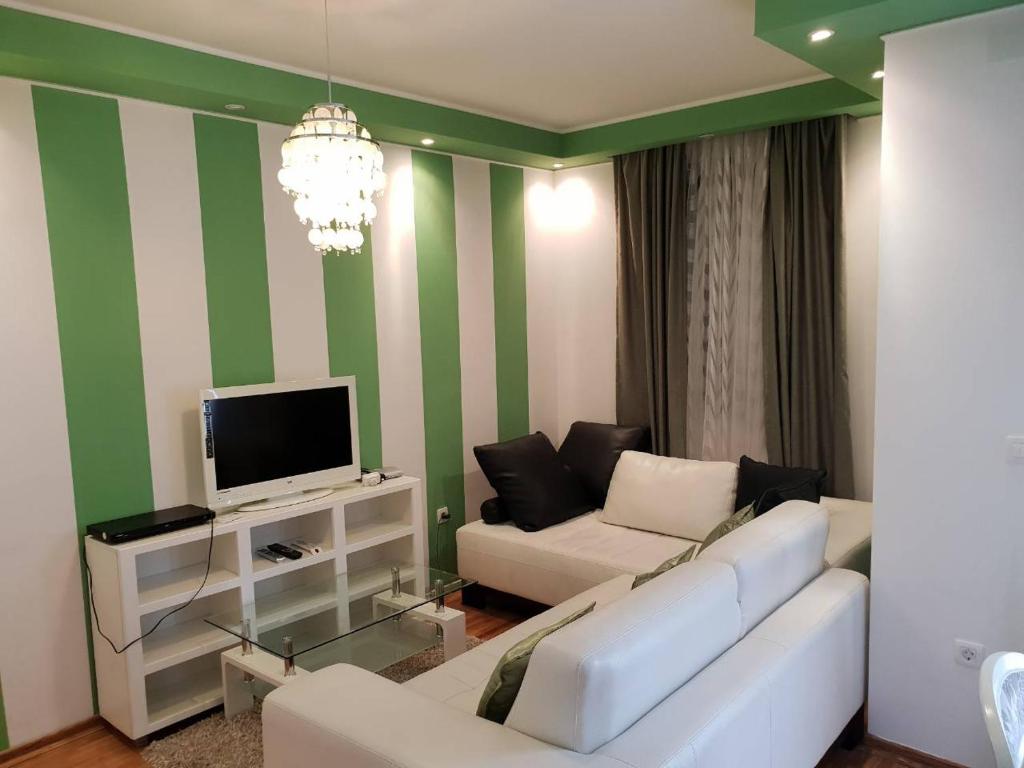 a living room with a white couch and a tv at Bozovic in Becici