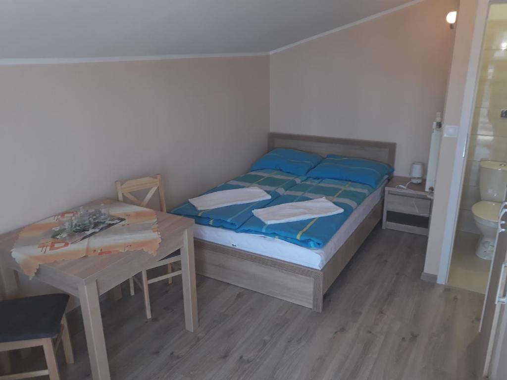 ブワディスワボボにあるPokoje gościnne Kaszub Władysławowoの小さなベッドルーム(ベッド1台、テーブル付)