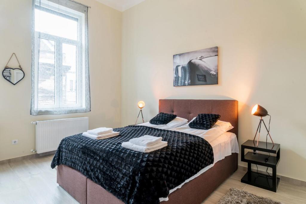 1 dormitorio con 1 cama grande y 2 toallas en K11 Exclusive Apartment at Szimpla, en Budapest