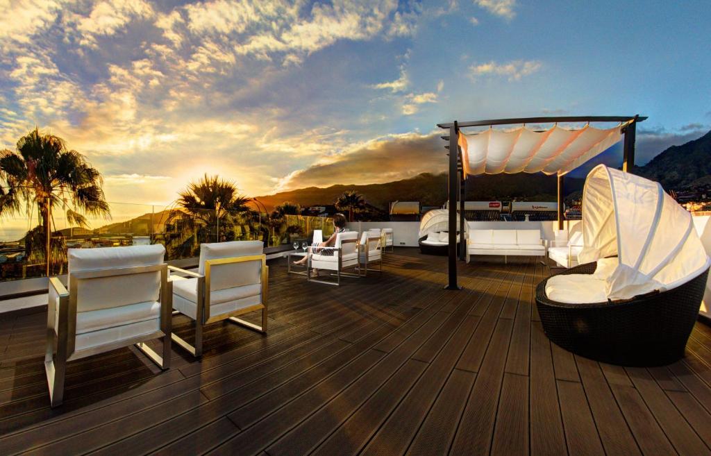 a deck with chairs and a gazebo on a yacht at Apartamentos Adjovimar in Los Llanos de Aridane