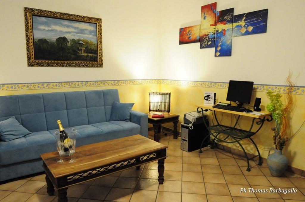 een woonkamer met een bank en een bureau met een computer bij B&B Giuseppe Verdi in Catania