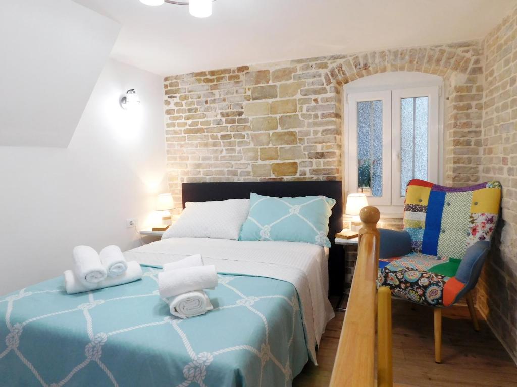 ein Schlafzimmer mit einem Bett und einem Stuhl in der Unterkunft Studio apartment Milla in Split