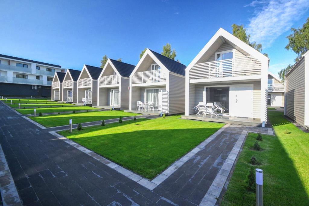 a row of houses with a green lawn at Xanadu Resort in Sianozety