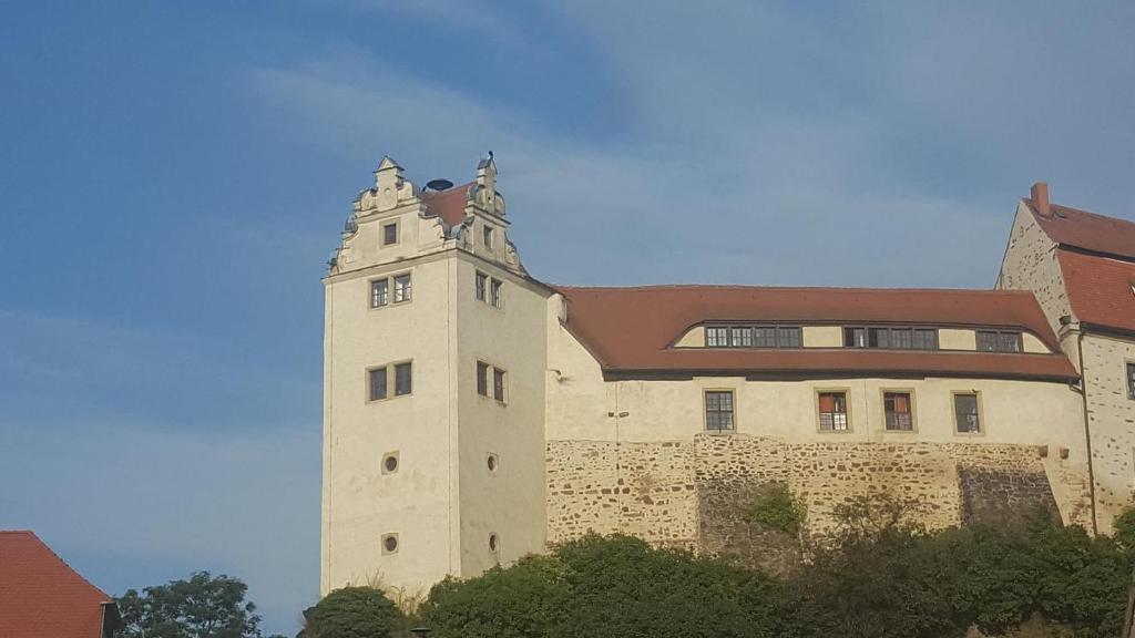 ein Gebäude mit einem Uhrturm darüber in der Unterkunft Ferienwohnung Wettin in Wettin