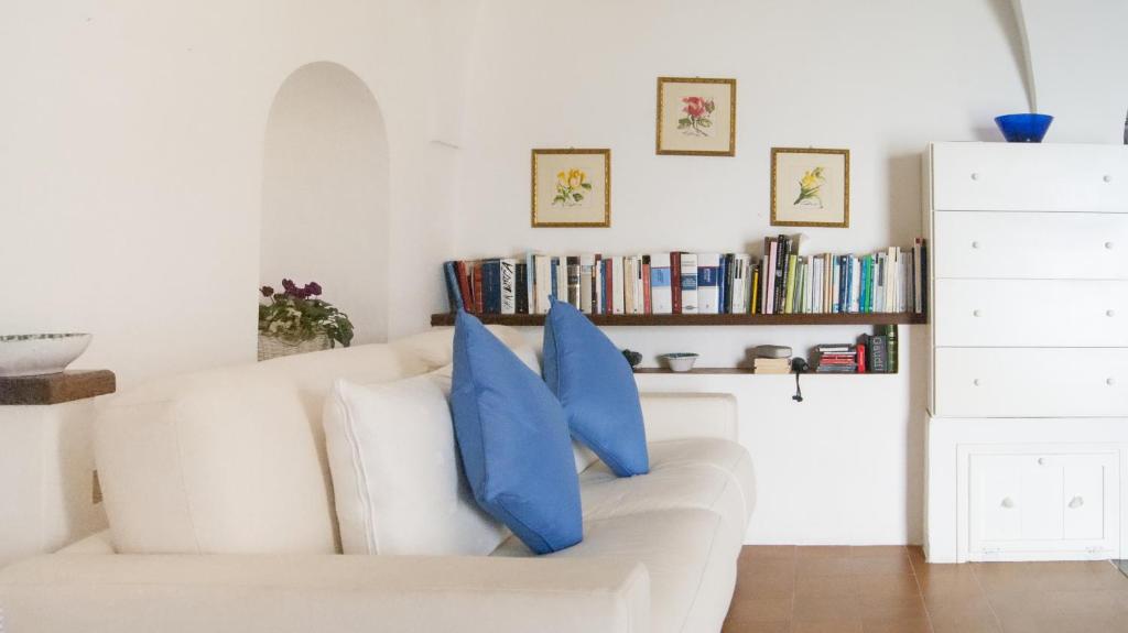 a living room with a white couch with blue pillows at Casavacanze Belvedere Sperlonga in Sperlonga