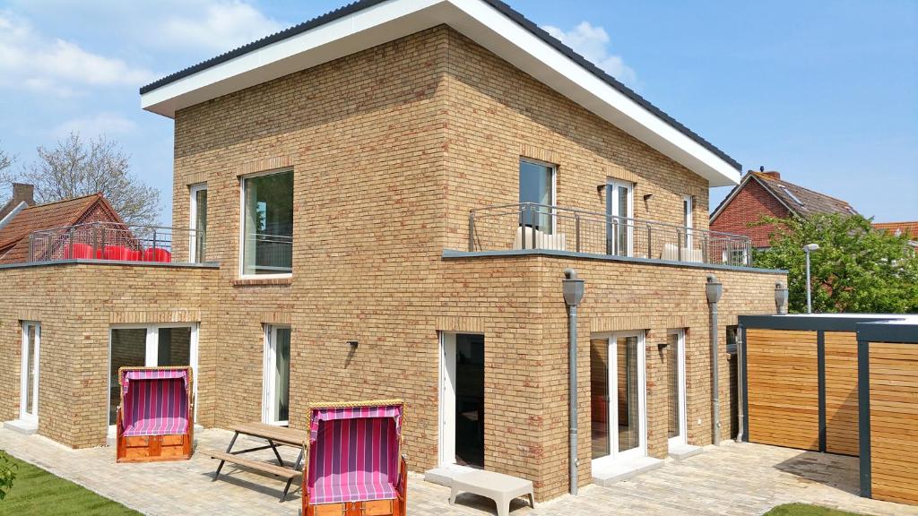 a brick house with two chairs in front of it at Kehrwieder No5 in Heiligenhafen