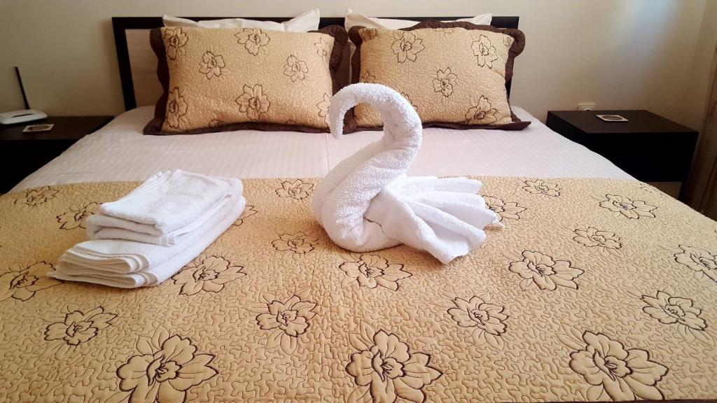 a swan sitting on top of a bed with towels at Cosy Apartment - City Centre in Blagoevgrad