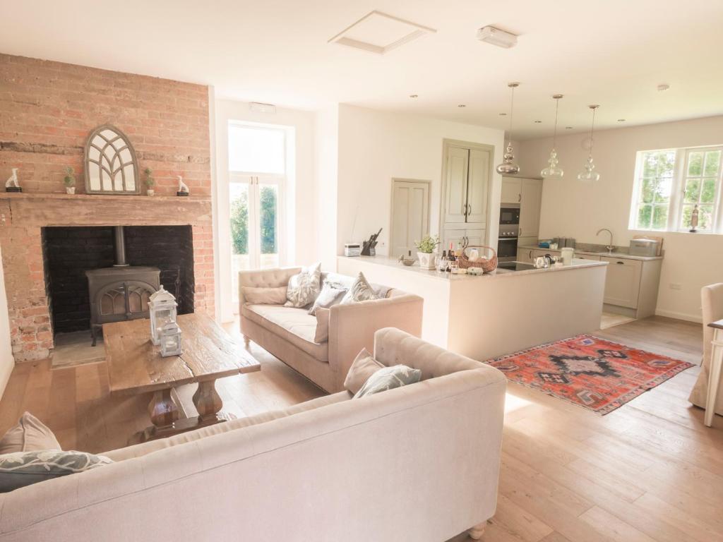a living room with white furniture and a fireplace at The Delaval Rooms in Lincoln