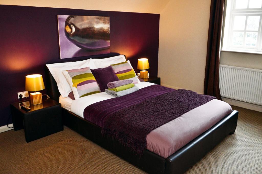 um quarto com uma cama grande com almofadas roxas e amarelas em Royal Forester Country Inn em Bewdley