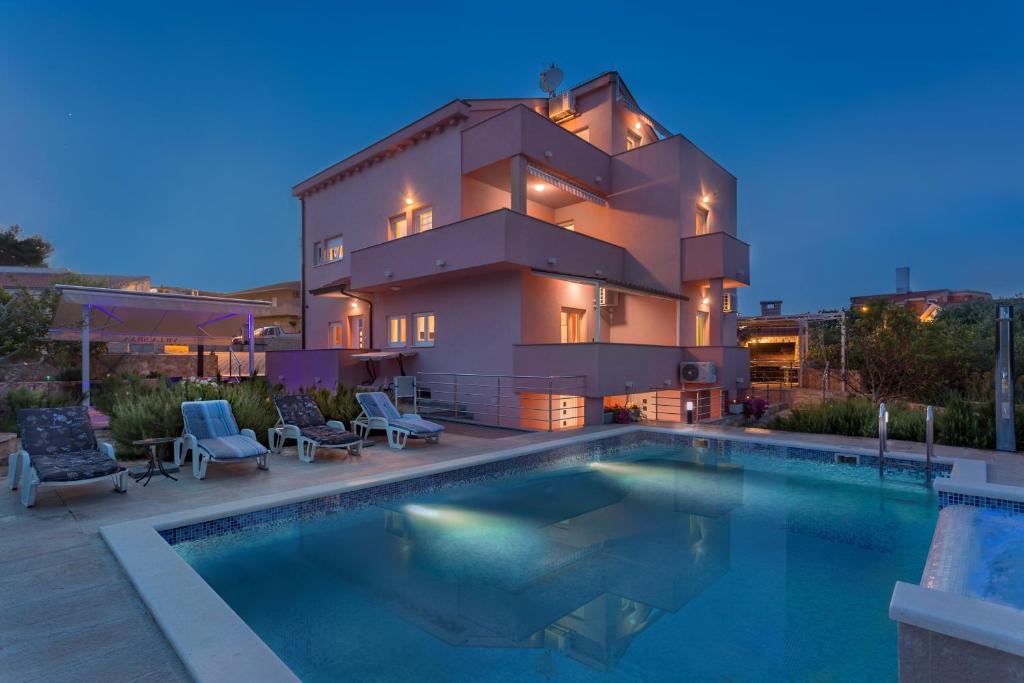 une maison avec une piscine en face de celle-ci dans l'établissement Apartments Silva, à Slatine