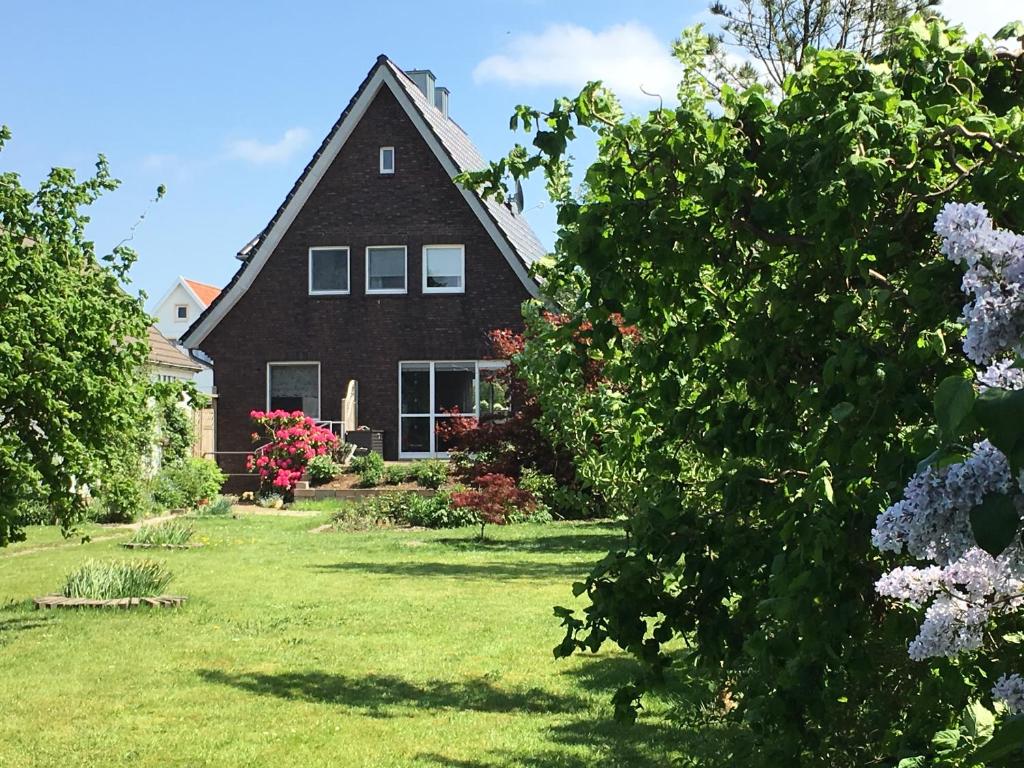 een groot huis met een tuin met bloemen bij Ferienhaus Scholien in Otterndorf