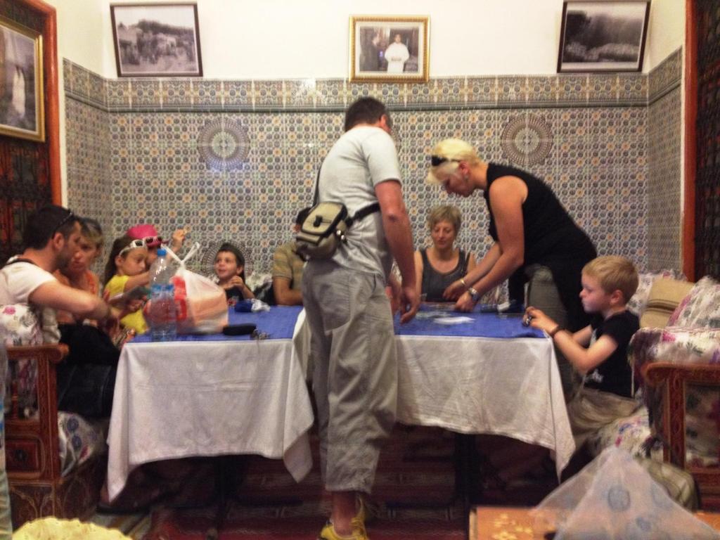 Un groupe de personnes assises autour de tables avec un gâteau dans l'établissement Al Andaloussiya Diyafa, à Moulay Idriss Zerhoun
