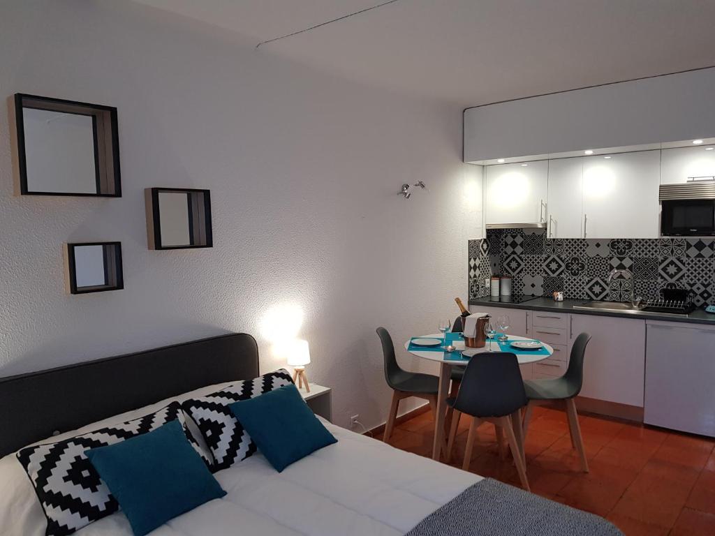 阿爾布費拉的住宿－Appartement piscine Albufeira 205C，一间卧室配有一张床铺和一张桌子,还设有一间厨房