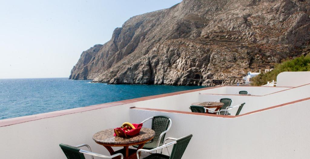 einen Balkon mit einem Tisch, Stühlen und Meerblick in der Unterkunft Irini's Rooms Fteoura in Kamari