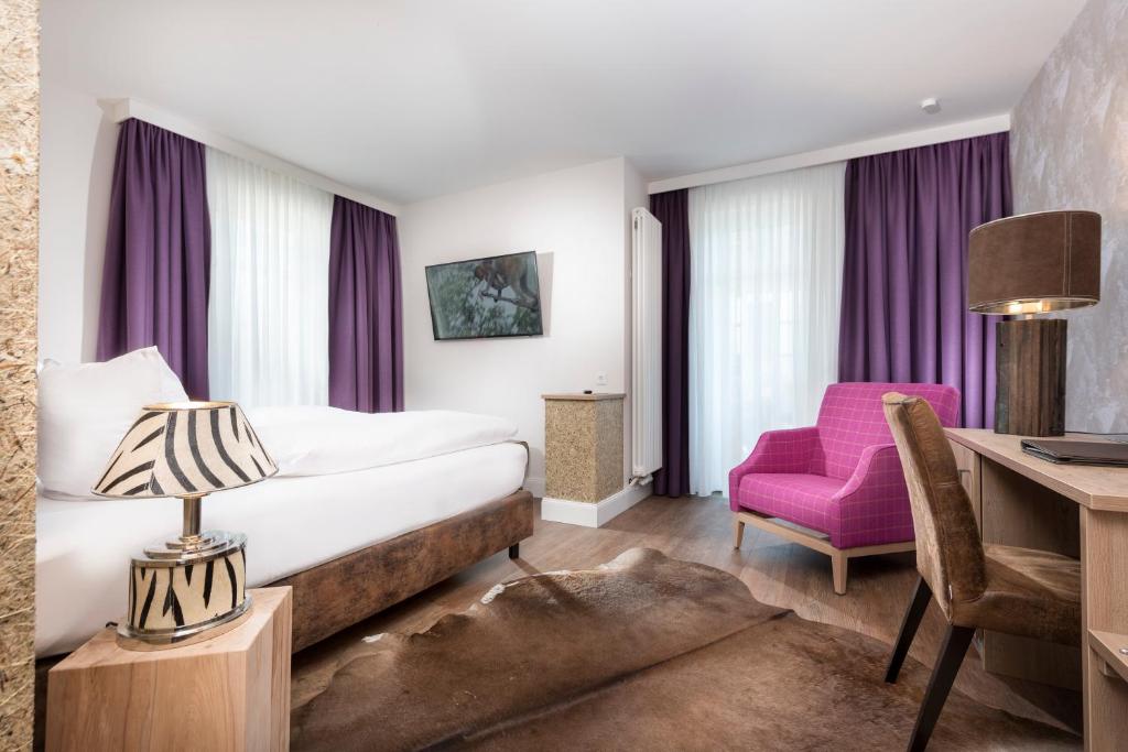 a hotel room with a bed and a desk and a chair at Hotel Linther Hof in Linthe