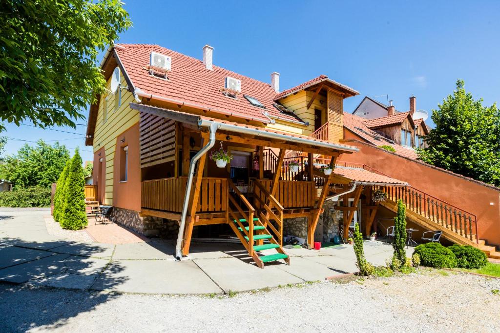 a house with a staircase in front of it at Almafa Apartmanház in Eger