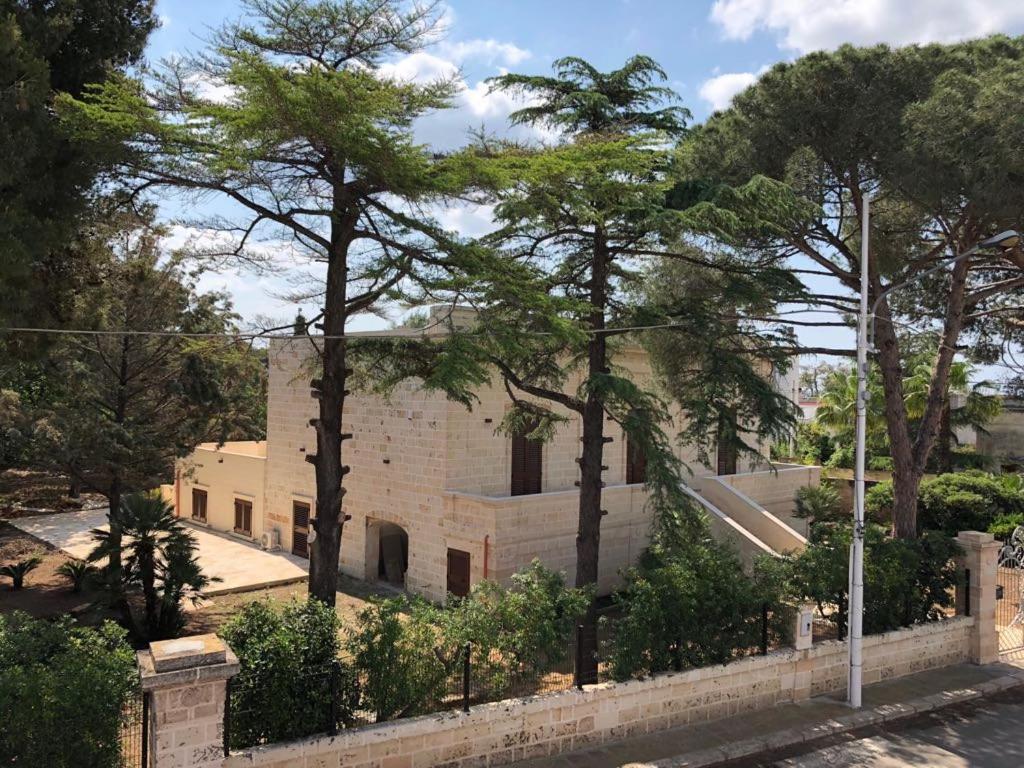 un gruppo di alberi di fronte a un edificio di B. & B. Lu Turnitu a Maruggio