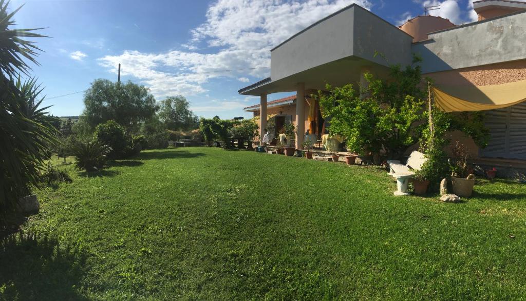 a yard next to a house with a green lawn at Guest house Villa di Judighes in Cerveteri