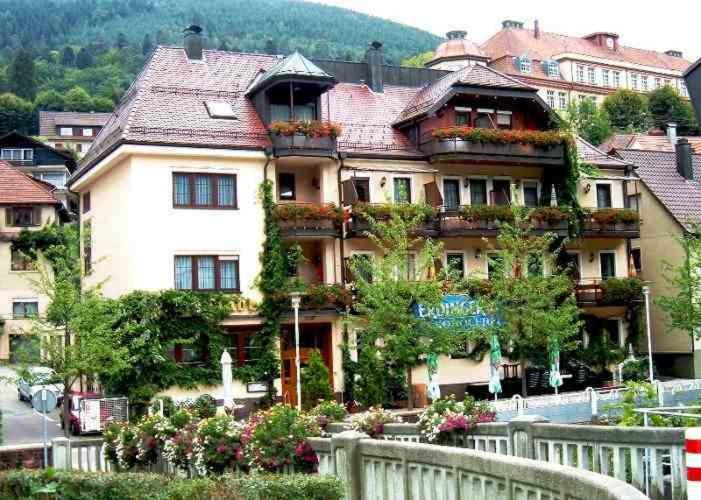 uma casa grande com uma cerca branca em frente em Hotel Restaurant Alte Linde em Bad Wildbad