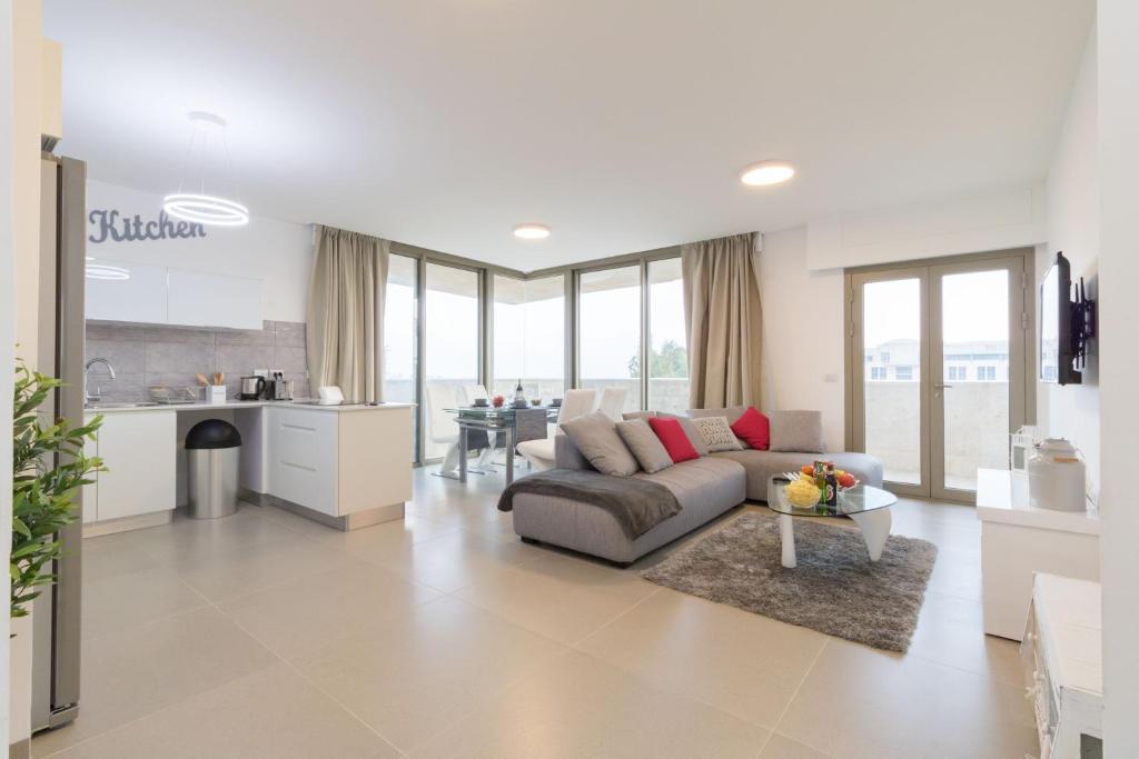 a living room with a couch and a kitchen at Luxury Two-Bedroom Apartment With Terrace Over Old City View in Jerusalem