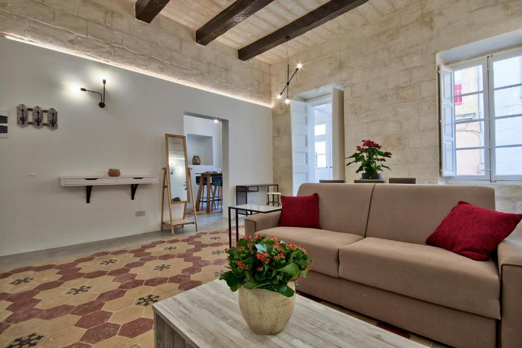 a living room with a couch and a table at Vallettastay Classic Apartments in Valletta