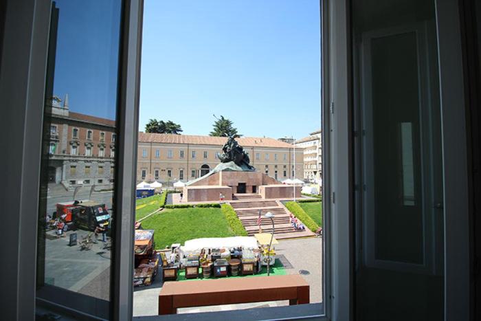 an open window with a view of a building with a statue at Piazza Trento 11 in Monza