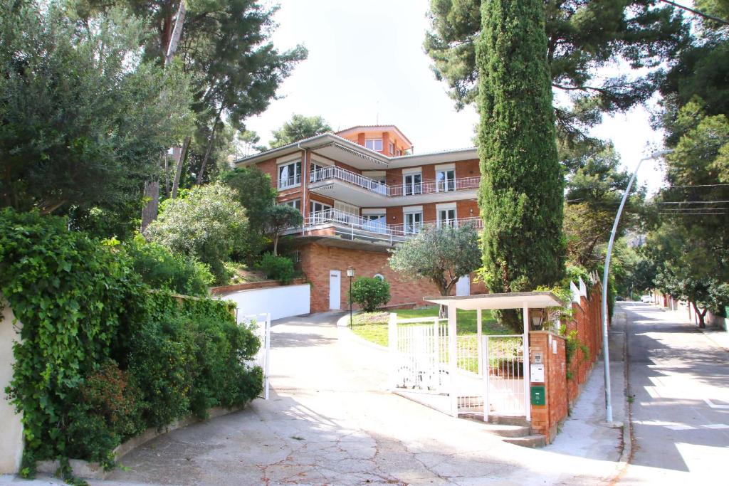 カステルデフェルスにあるGran Villa entre mar y montañaの門と木のある道の家