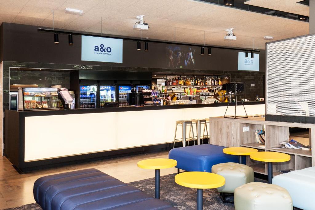 a bar with yellow and blue stools and a counter at a&o Prague Rhea in Prague